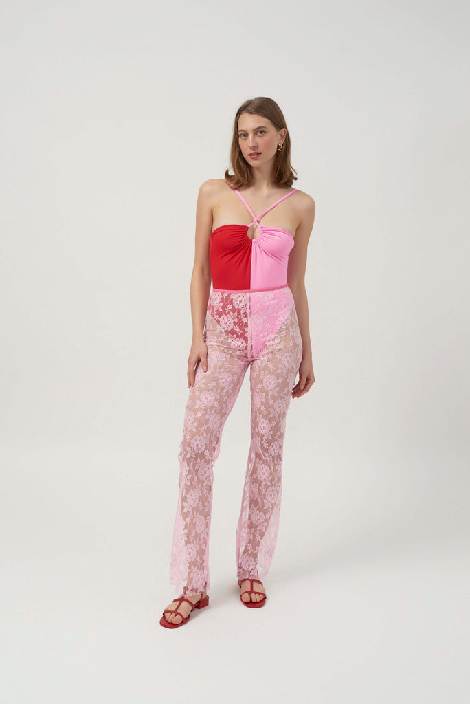 Our design features transparent trousers, crafted from a beautiful, pink lace fabric. In the picture it is paired with our unique pink and red swimsuit